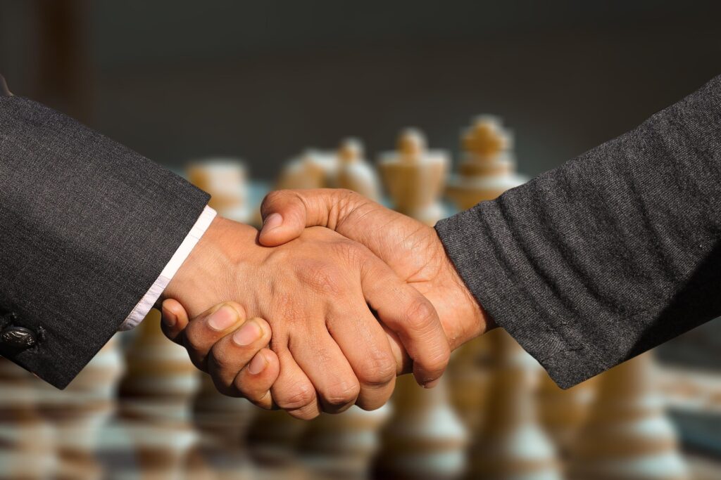 handshake in front of a chess board