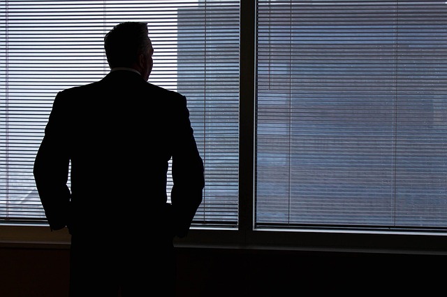 sillouette of business person staring out window contemplating how much is my business worth