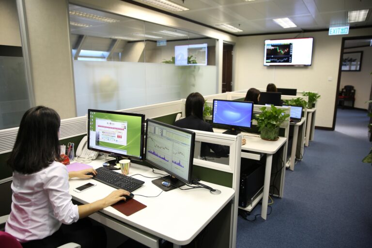 people working at desks in a row in an office