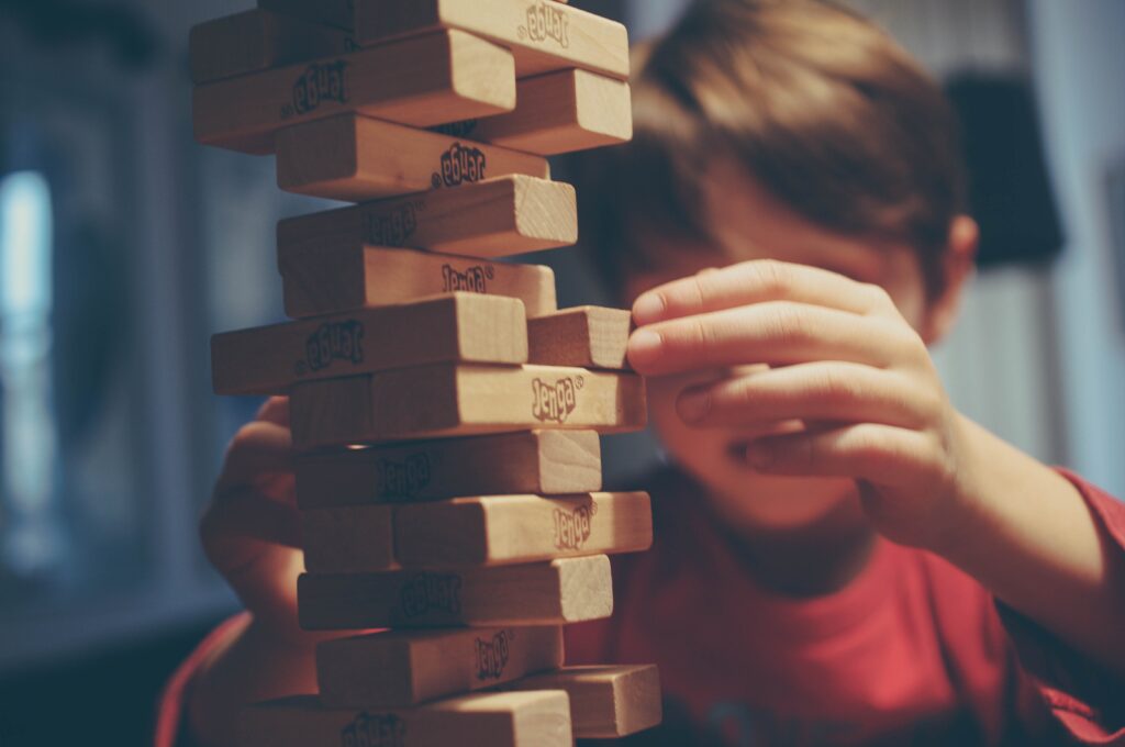 child playing tower game symbolizing understanding the risk of removing one large client from your business